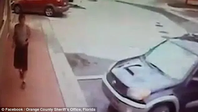 The man, wearing a grey or white tank top and a pair of black shorts walking outside the McDonald's